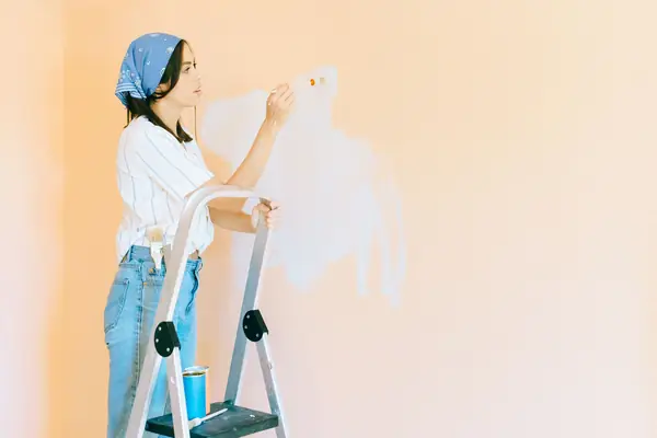Interior painting in Wichita: painter on a stepladder rolling a wall